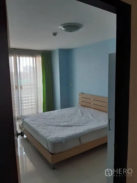 คอนโด ขายในWatthana, Bangkok - ห้องนอนที่สองบรรยากาศอบอุ่น ผนังสีฟ้า เตียง และประตูกระจกออกระเบียงพร้อมผ้าม่านสีเขียว