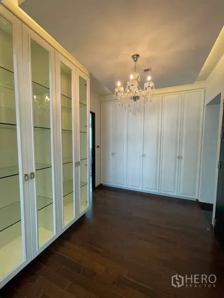 บ้าน ให้เช่าหรือขายในLat Krabang, Bangkok - โถงแต่งตัวมีตู้โชว์กระจก โคมไฟแชนเดอเลียร์ และตู้เสื้อผ้าสีขาว