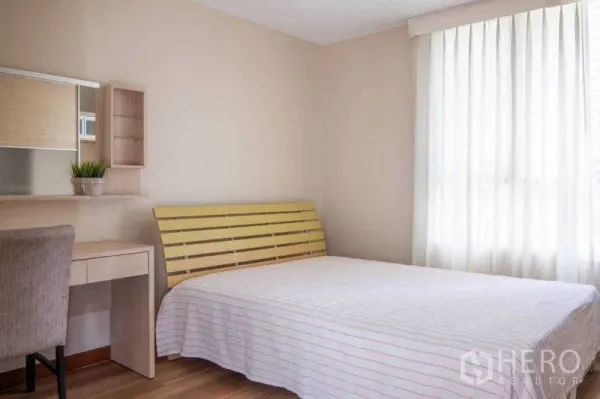 Condominium for rent in Pathum Wan, Bangkok - Second bedroom featuring bed, work desk, wall shelf and large window with curtains