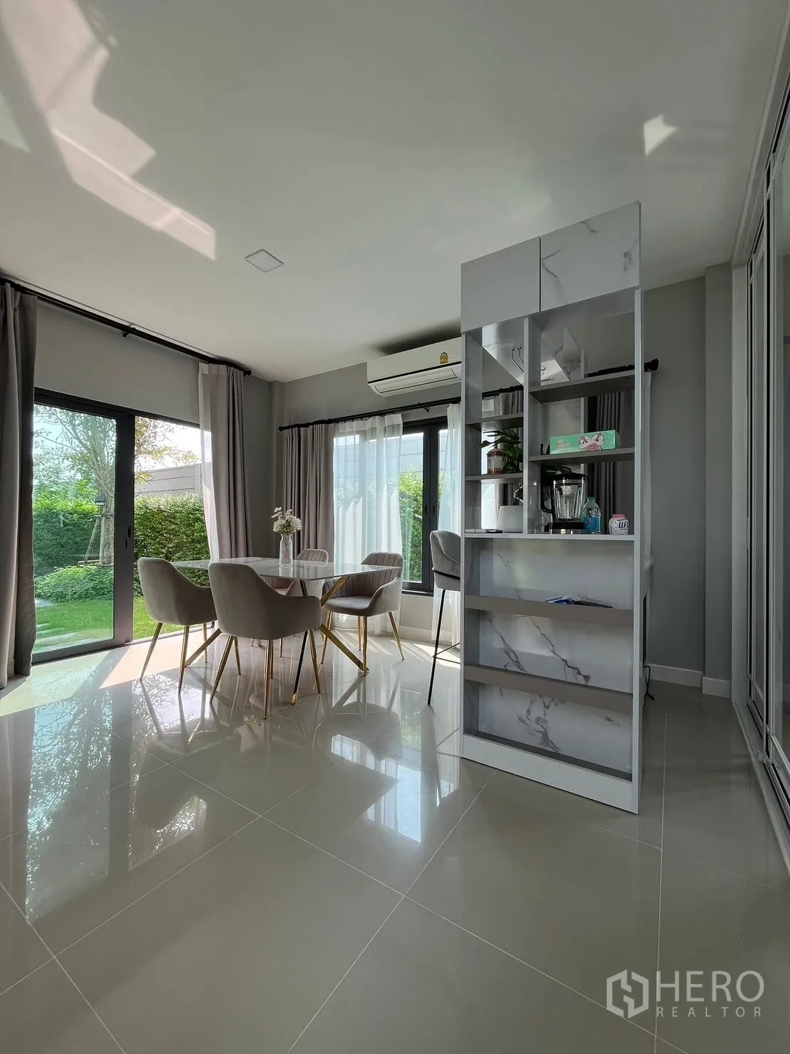 Detached House for rent in Bang Phli, Samut Prakan - Sunny dining nook with shelves and panoramic sliding doors overlooking a green garden.