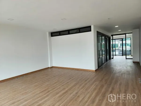 带办公室的家 出租在Prawet, Bangkok - 长形开放工作区，木地板与玻璃隔断，尽头可通往阳台。