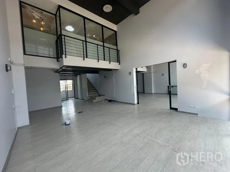 Home Office for rent - Vast hall with mezzanine, staircase and sliding glass partitions.