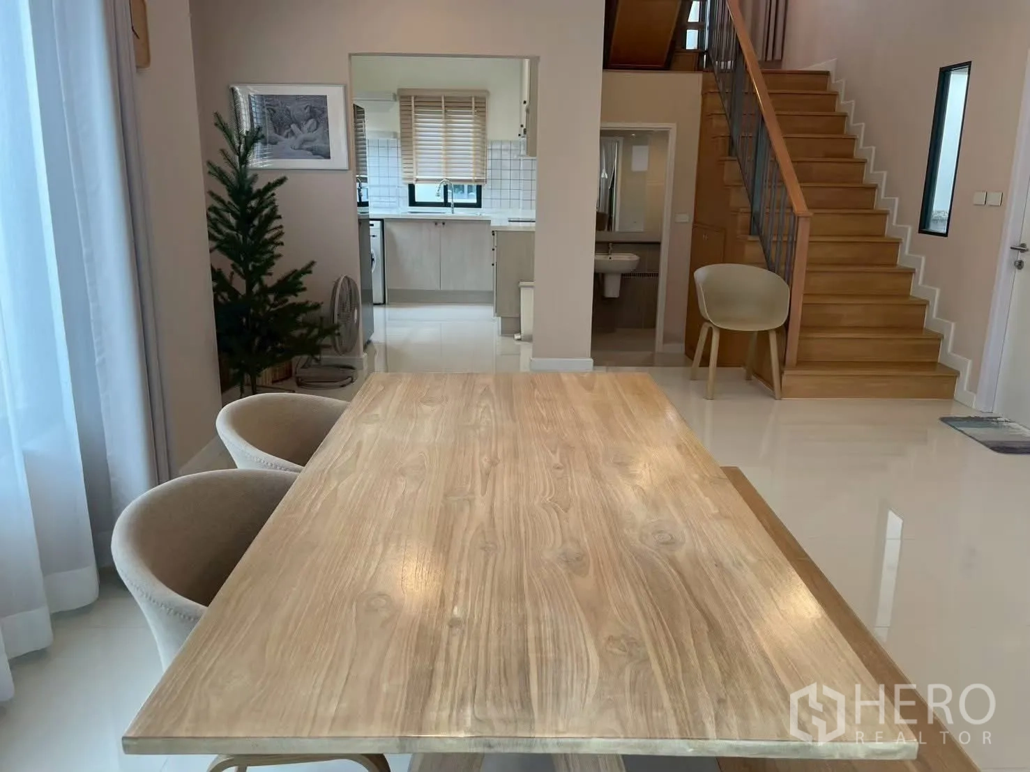 Detached House for rent in Bang Phli, Samut Prakan - Dining table view toward the kitchen and timber staircase.