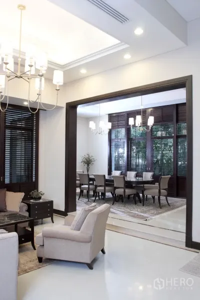 บ้าน ให้เช่าในKhlong Toei, Bangkok - ห้องนั่งเล่นสว่างเชื่อมต่อห้องรับประทานอาหาร ตกแต่งโคมระย้า กรอบไม้เข้ม และบานหน้าต่างขนาดใหญ่