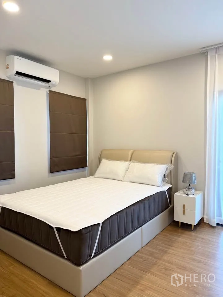 Detached House for rent in Bang Phli, Samut Prakan - Bedroom with air conditioner, double windows, and bedside table.