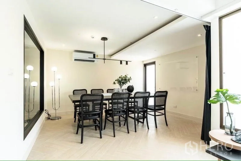 Office Space for rent in Khlong Toei, Bangkok - Large meeting room with a long table, ten black chairs, pendant lighting, glass whiteboard and wide windows.