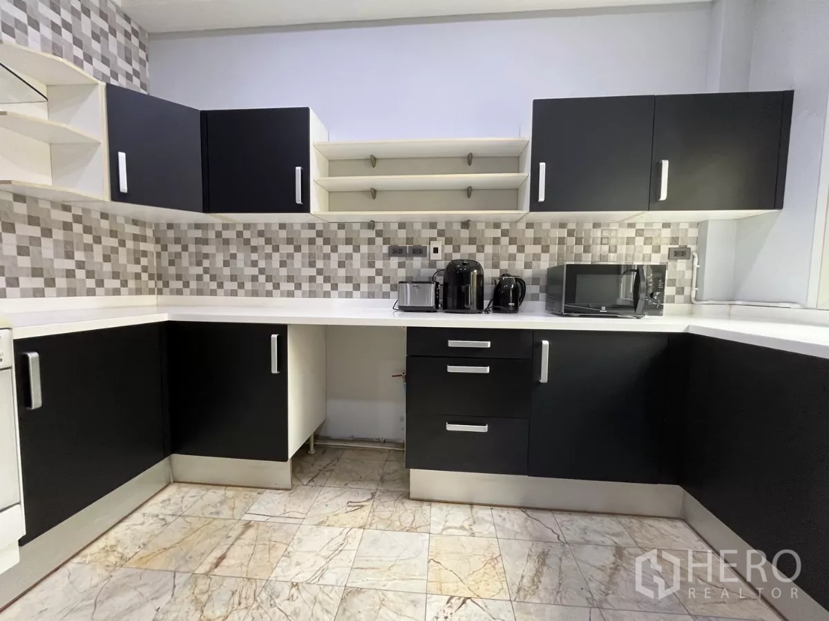 Home Office for rent - U‑shaped kitchen cabinetry with small appliances and a window for natural light