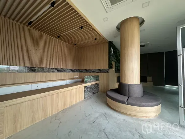 零售空间 出租在Phra Khanong, Bangkok - 接待区配木格栅天花、长服务台与柱体环形座椅的现代零售单元。