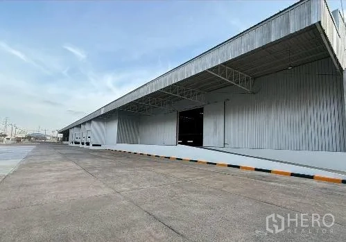 Factory for rent in Si Racha, Chon Buri - Metal-clad warehouse exterior with covered loading bays and wide driveway.