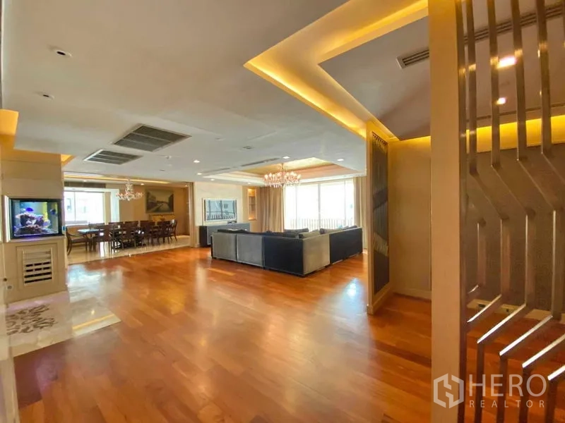 คอนโด ให้เช่าในKhlong Toei, Bangkok - พื้นที่นั่งเล่นเปิดโล่ง โดดเด่นด้วยตู้ปลา ไฟซ่อน และพื้นไม้