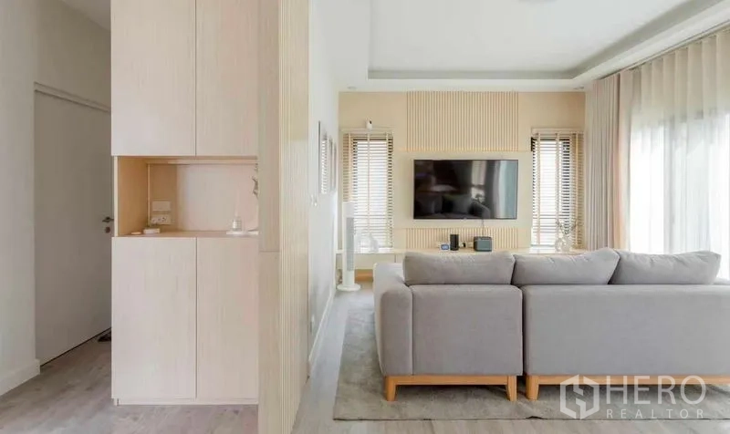 Detached House for rent in Bang Khun Thian, Bangkok - Partial living room view from corridor with sofa and TV feature wall.