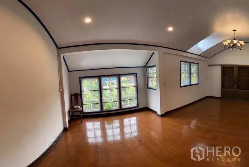 บ้าน ให้เช่าในKhlong San, Bangkok - ห้องนั่งเล่นกว้าง เพดานโค้ง โคมระย้า และพื้นไม้ขัดเงา