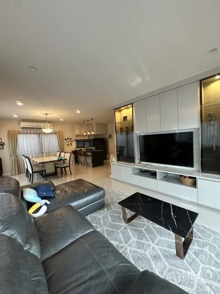 บ้าน ให้เช่าหรือขายในLam Luk Ka, Pathum Thani - ห้องนั่งเล่นแบบโอเพ่นสเปซ โซฟาหนังขนาดใหญ่ ตู้บิลท์อินทีวี มองเชื่อมไปยังครัวและทานอาหาร