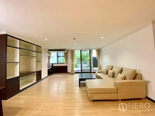 คอนโด ให้เช่าหรือขายในWatthana, Bangkok - ห้องนั่งเล่นกว้าง โซฟาเข้ามุม ชั้นบิวท์อิน และประตูกระจกสไลด์ออกสู่ระเบียง