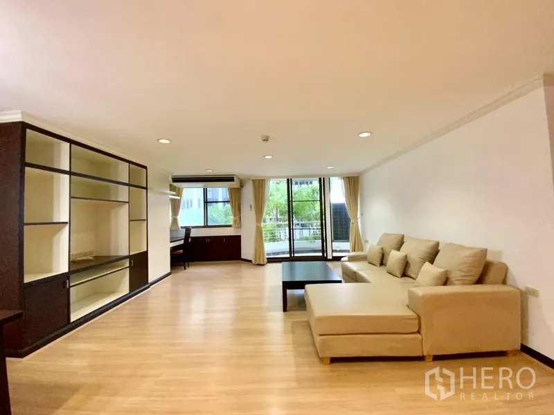 คอนโด ให้เช่าหรือขายในWatthana, Bangkok - ห้องนั่งเล่นกว้าง โซฟาเข้ามุม ชั้นบิวท์อิน และประตูกระจกสไลด์ออกสู่ระเบียง