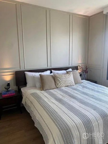 คอนโด ให้เช่าในRatchathewi, Bangkok - ห้องนอนหลักผนังเซาะร่อง เตียงคิงไซซ์ ชุดเครื่องนอนโทนอบอุ่น และโต๊ะหัวเตียง