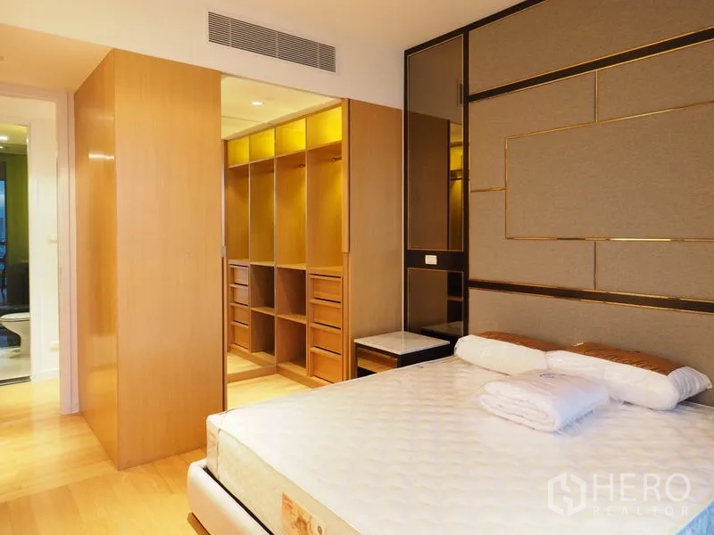 Condominium for rent in Yan Nawa, Bangkok - Primary bedroom with luxurious headboard and illuminated walk-in closet.