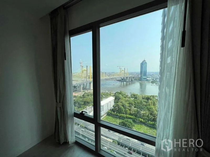 Condominium for sale - Bedroom window framing river, bridge and green parkland below.