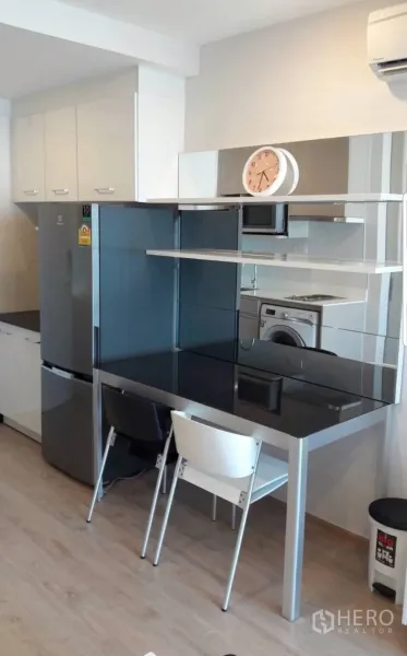 Condominium for rent in Bang Rak, Bangkok - Compact kitchenette with full-size fridge, black-glass dining counter, cabinets and washer.