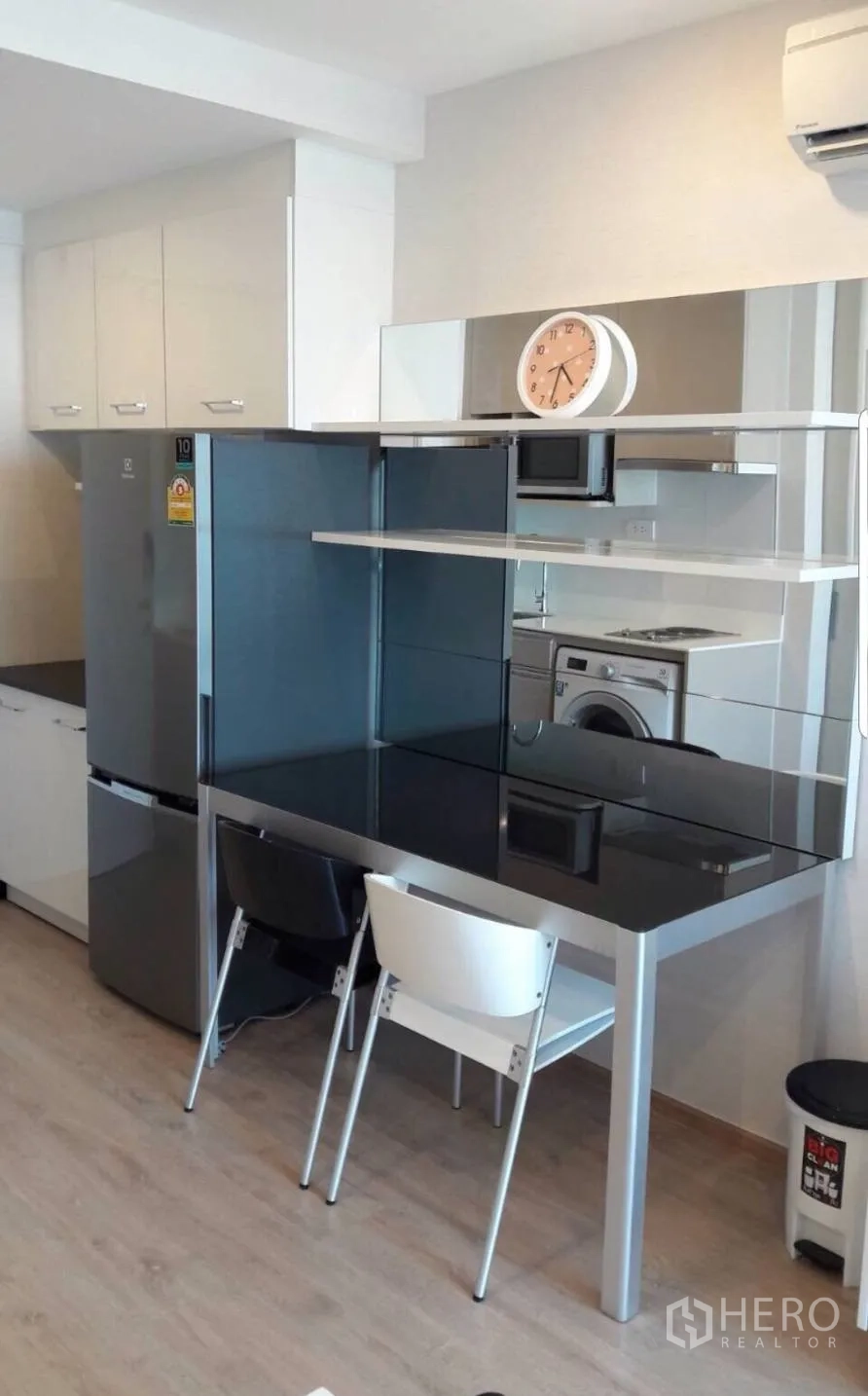 Condominium for rent in Bang Rak, Bangkok - Compact kitchenette with full-size fridge, black-glass dining counter, cabinets and washer.