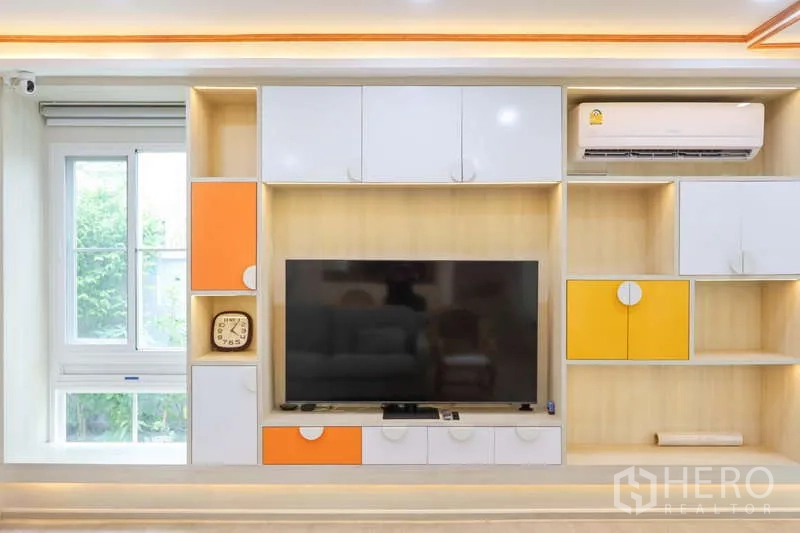 Detached House for rent or sale in Prawet, Bangkok - Close-up of built-in TV cabinet with white and orange storage and air conditioner.