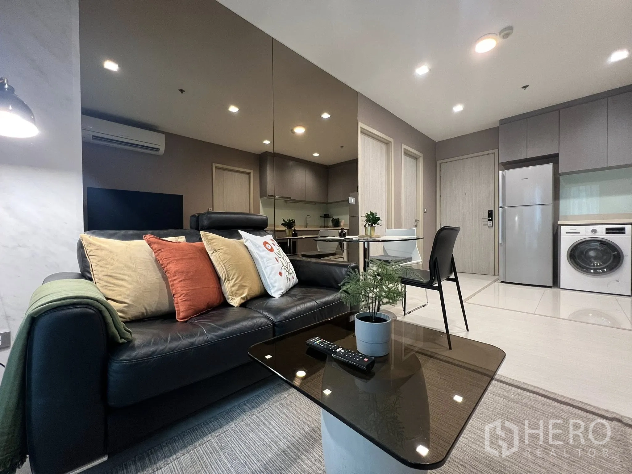 公寓 for rent in Khlong Toei, Bangkok - 开放式客厅配皮沙发、茶几、圆形餐桌与亮面地砖。