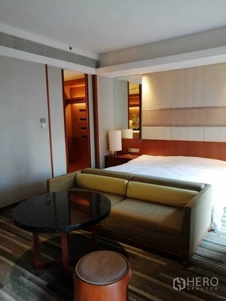 คอนโด ให้เช่าในPathum Wan, Bangkok - มุมมองห้องนอน เตียง โซฟาตัวเล็ก และโต๊ะกลมข้างเตียง