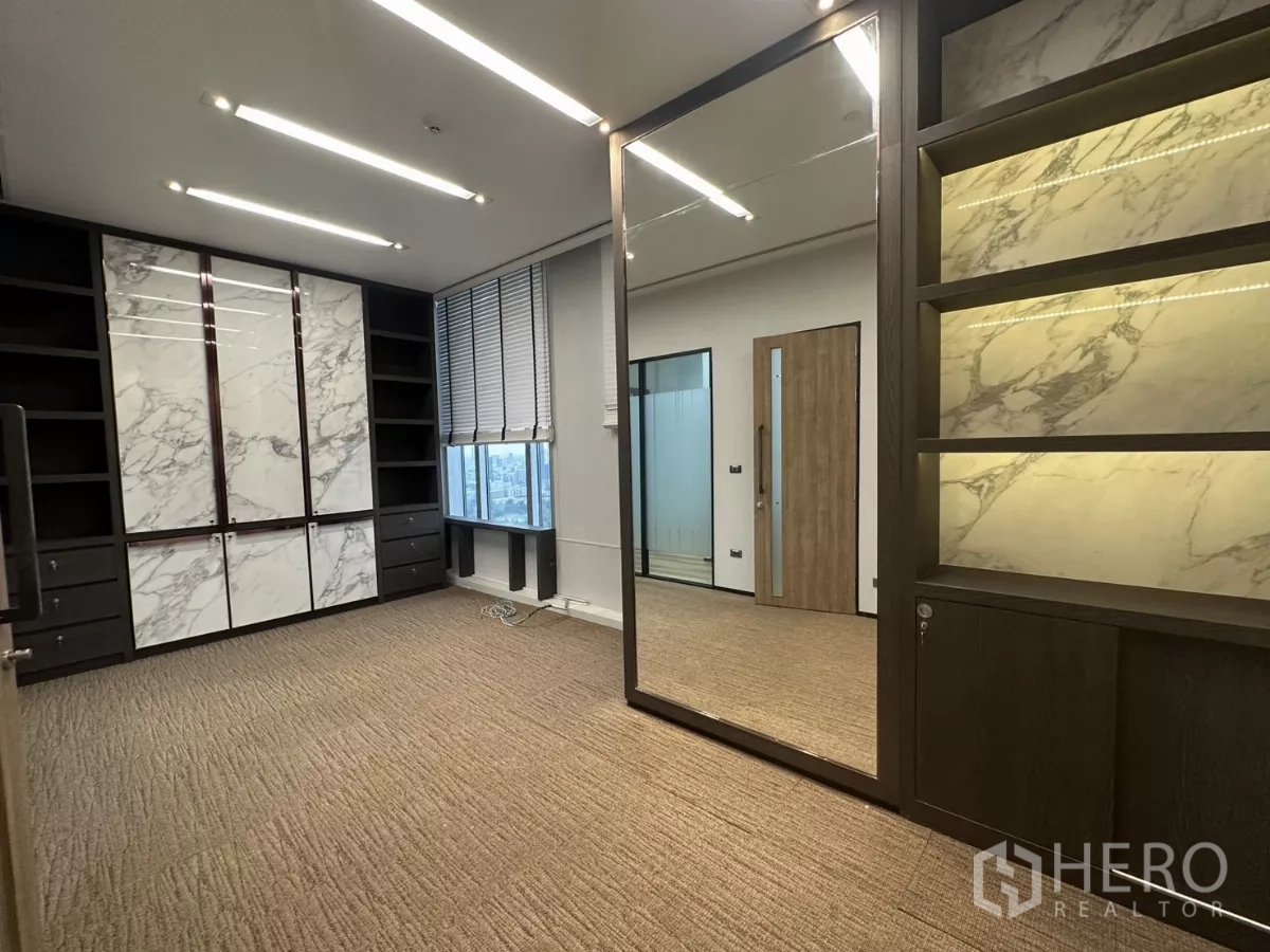 办公空间 出租在Watthana, Bangkok - 行政套间，带大理石装饰柜、开放式书架与落地镜。