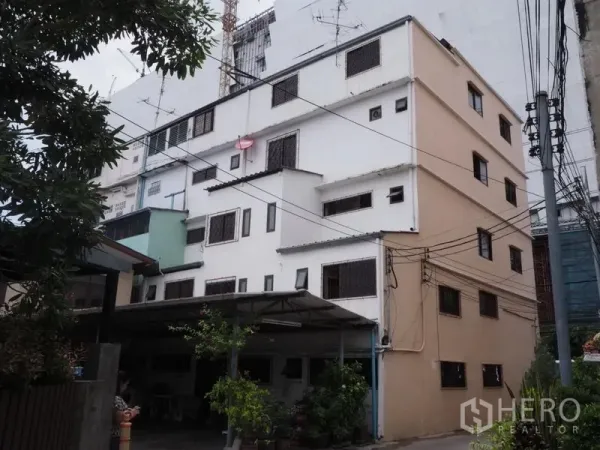 อาคารพาณิชย์ ขายในKhlong San, Bangkok - อาคารพาณิชย์หลายชั้น ภายนอกสีครีม–ขาว มีเหล็กดัดและสายสื่อสาร ในย่านคลองสาน
