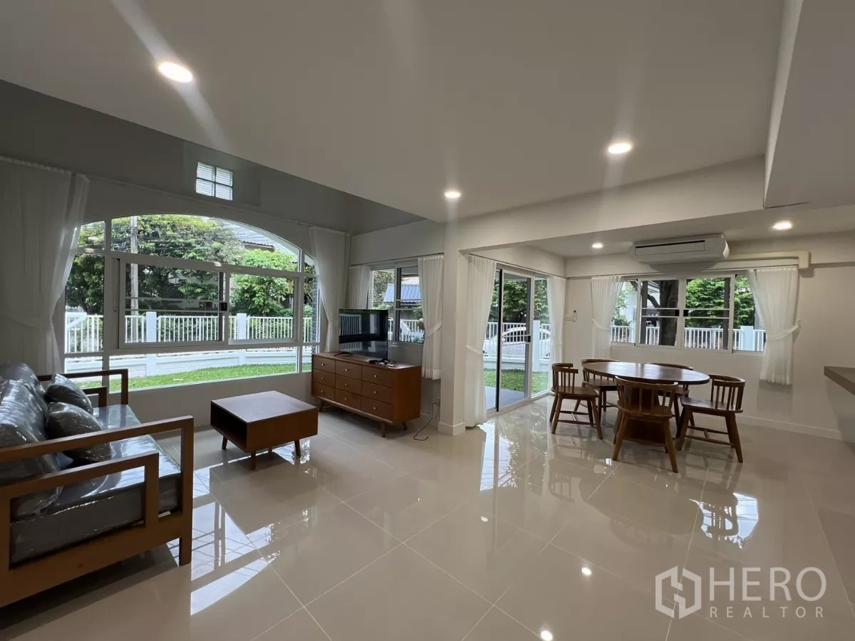 Detached House for rent in Saphan Sung, Bangkok - Bright open-plan living and dining room with large windows facing the lawn.