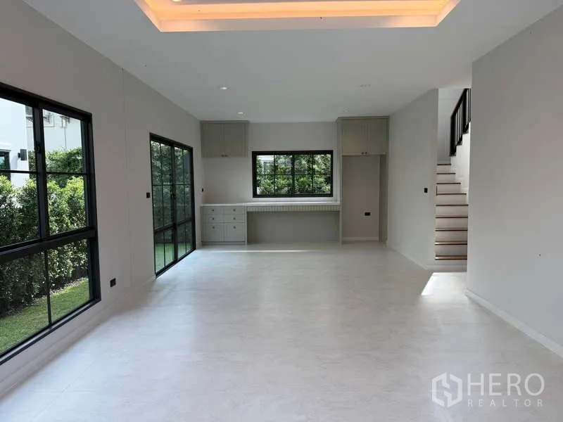 Detached House for rent or sale in Bang Phli, Samut Prakan - Dining and living zone with sliding glass doors to the garden and built-in cabinets.