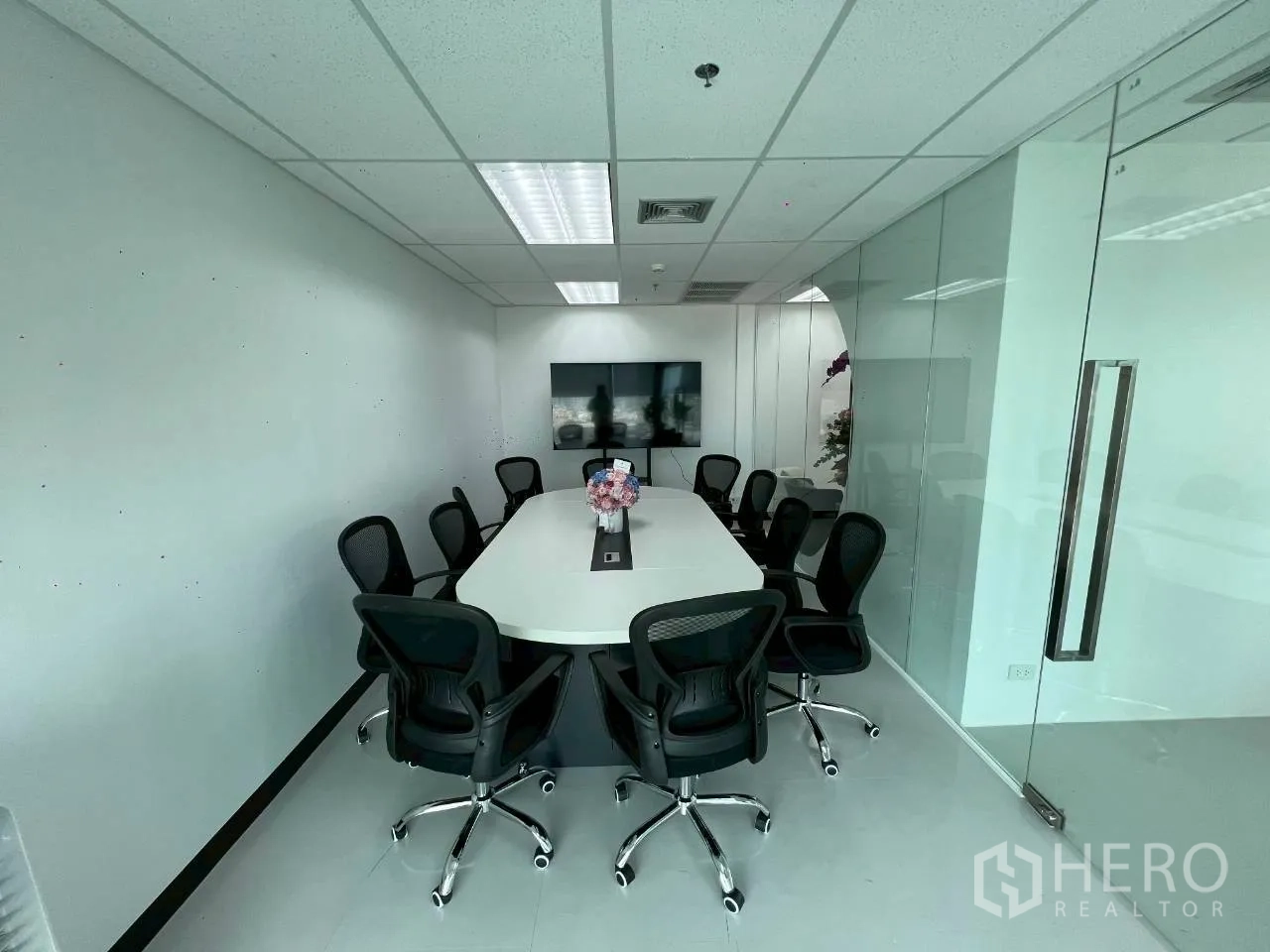 Office Space for rent in Din Daeng, Bangkok - Glass-walled meeting room with a long conference table and swivel chairs.