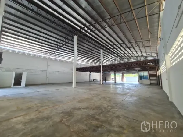 Warehouse for rent in Khlong Toei, Bangkok - Open warehouse space with mezzanine, central columns and skylight panels.