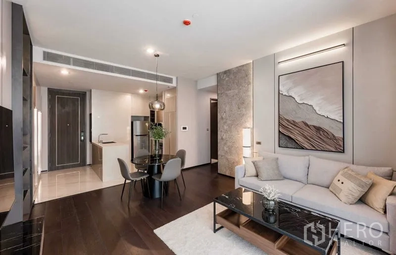 คอนโด ให้เช่าในWatthana, Bangkok - ห้องนั่งเล่นสว่างด้วยแสงธรรมชาติ โซฟา โต๊ะอาหารทรงกลม และมุมมองไปยังครัว