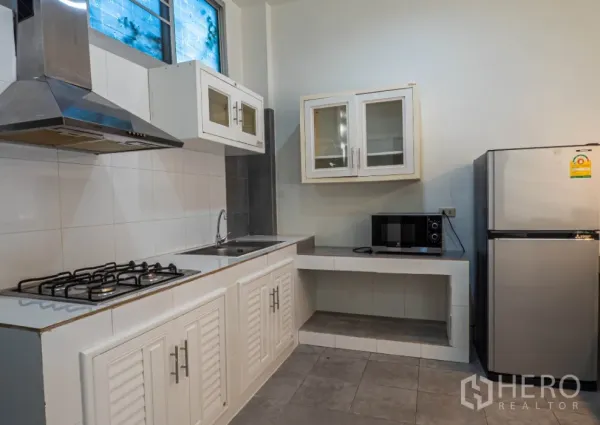 ทาวน์เฮาส์ ให้เช่าในKhlong Toei, Bangkok - ครัวโทนขาวมีเตาแก๊ส เครื่องดูดควัน ตู้แขวนกระจก ไมโครเวฟ และตู้เย็นสแตนเลส