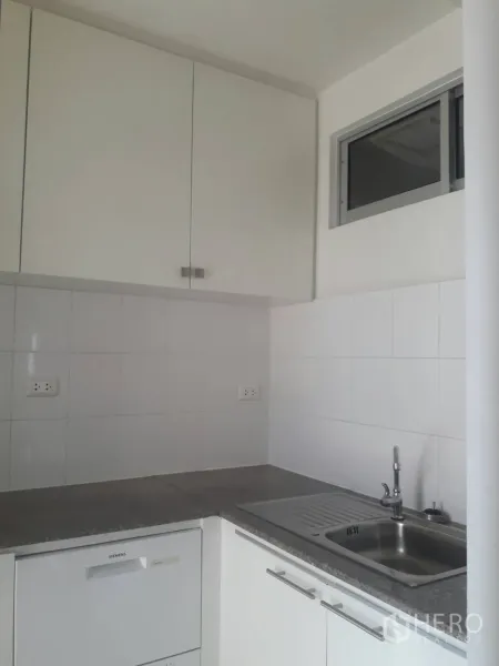 คอนโด ให้เช่าในKhlong Toei, Bangkok - ครัวรูปตัวแอลโทนขาว ผนังกระเบื้อง ตู้ลอย อ่างล้างจานสแตนเลส และหน้าต่างบานเลื่อนขนาดเล็ก