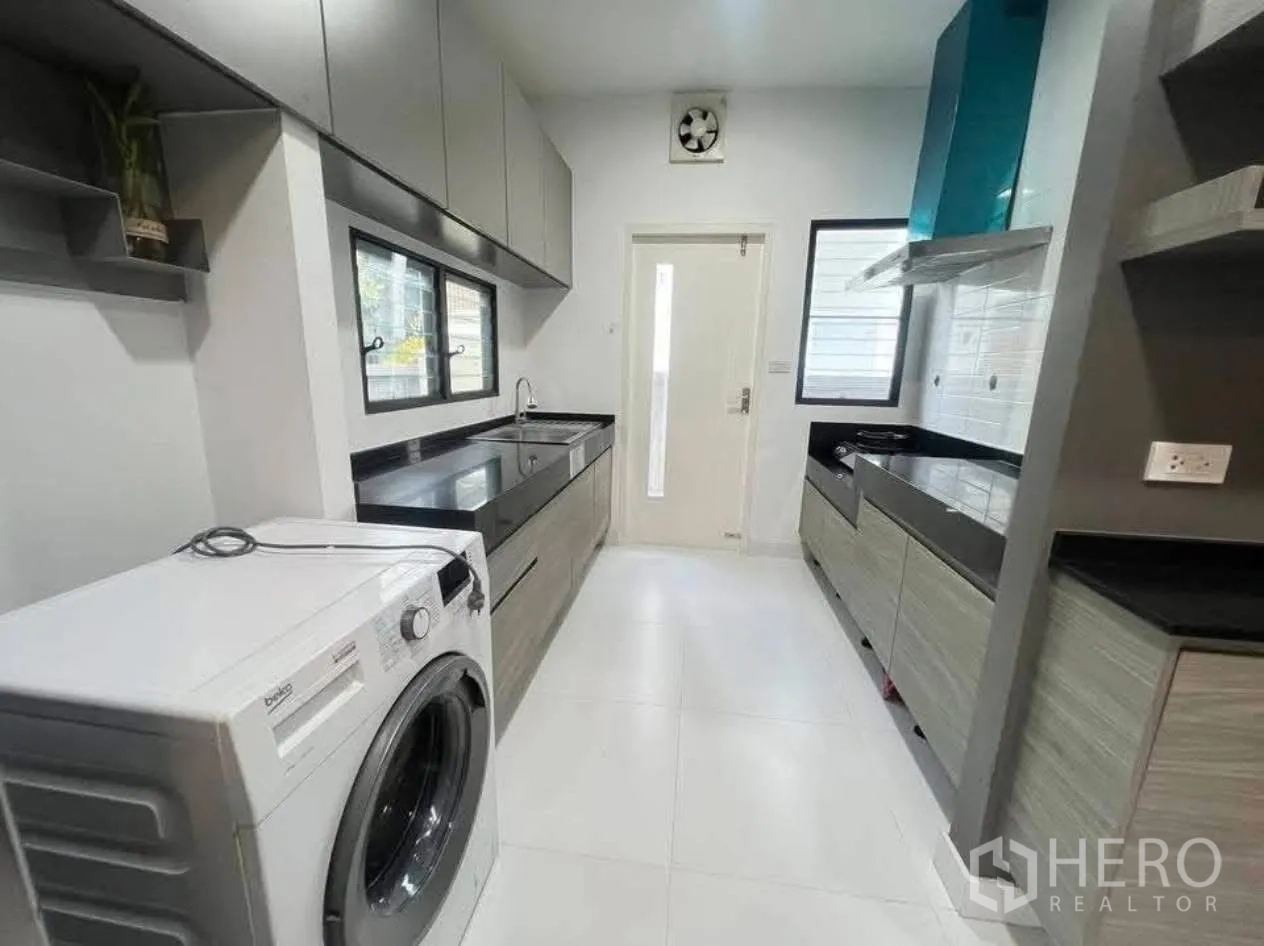 บ้านเดี่ยว for rent in Bang Phli, Samut Prakan - ครัวแบบกัลเลย์ยาว เคาน์เตอร์สีดำ ตู้เก็บของเยอะ และเครื่องซักผ้า