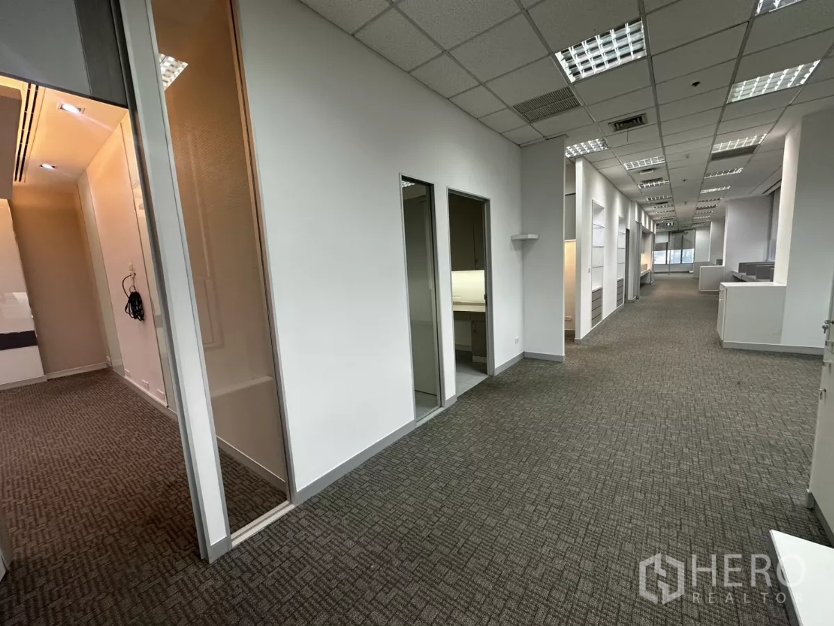 办公空间 出租在Watthana, Bangkok - 长走廊连接多间房，玻璃隔断与地毯地面。
