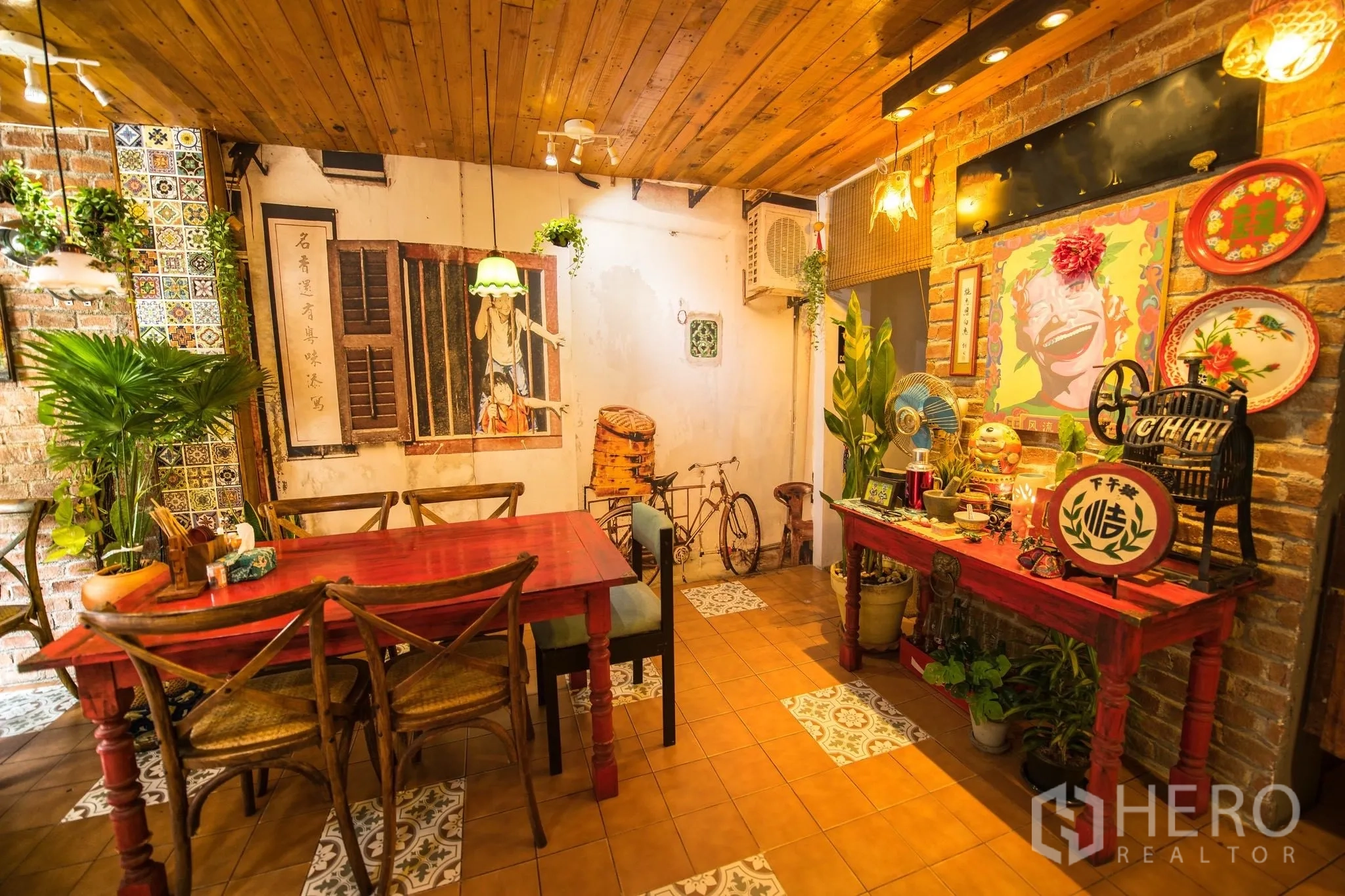 零售空间 for rent in Watthana, Bangkok - 带墙绘的装饰角落，复古摆件、绿植与红色桌子。