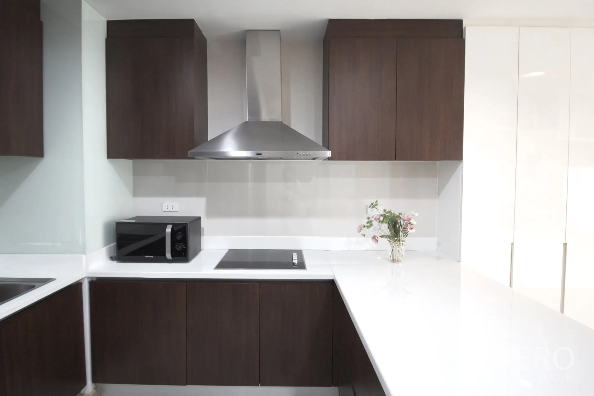 คอนโด for rent in Pathum Wan, Bangkok - ครัวยูเชพทันสมัย ท็อปสีขาว ตู้ไม้เข้ม เตา เครื่องดูดควัน และไมโครเวฟ