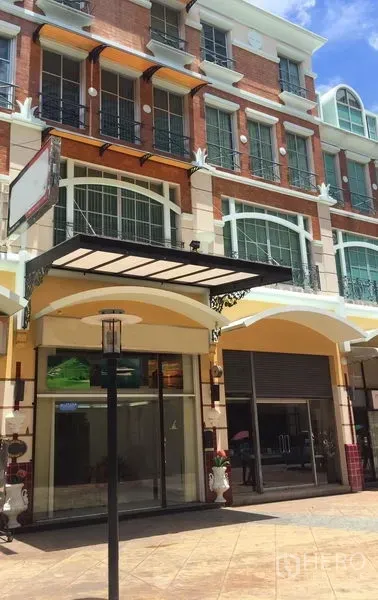 สำนักงานที่บ้าน ให้เช่าหรือขายในSathon, Bangkok - ด้านหน้าอาคารโฮมออฟฟิศสไตล์ยุโรปหลายชั้น หน้ากระจกพร้อมกันสาดและประตูม้วน ใต้ท้องฟ้าแจ่มใส