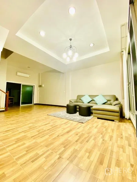 联排别墅 出租在Prawet, Bangkok - 宽敞开放客餐厅，木地板、嵌灯与大窗户。