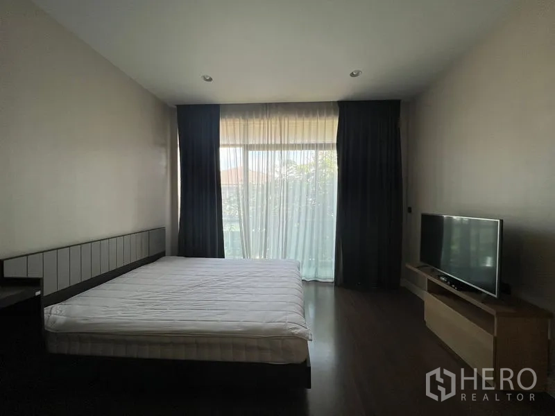 บ้าน ให้เช่าหรือขายในBang Kapi, Bangkok - ห้องนอนพร้อมหน้าต่างบานใหญ่ เตียง และชั้นวางทีวีหันสู่ประตูกระจก