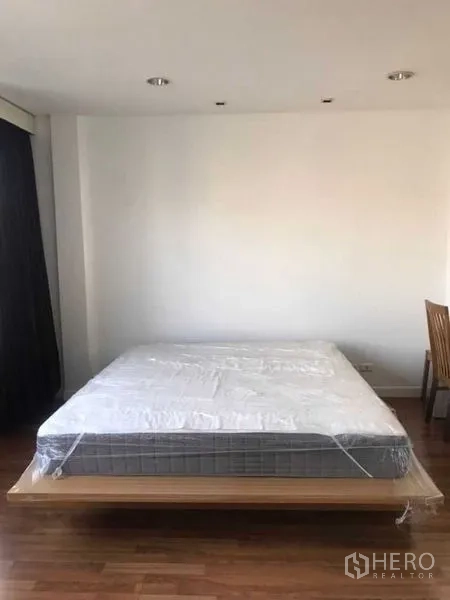 Townhouse for rent in Bang Kapi, Bangkok - Wide bedroom featuring a platform bed, recessed lighting, and minimalist decor.