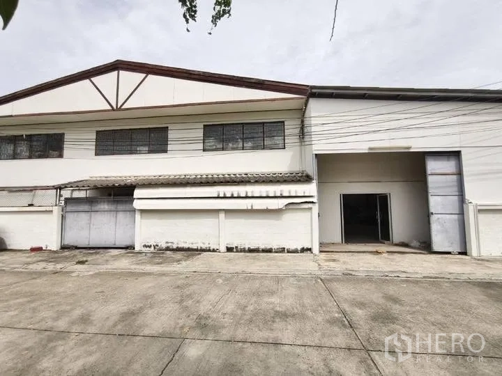 Warehouse for rent in Prawet, Bangkok - Warehouse exterior with tall loading door and wide driveway apron.