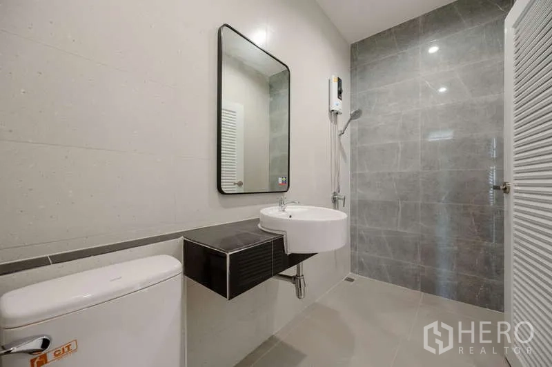 ทาวน์เฮาส์ ขายในLat Phrao, Bangkok - ห้องน้ำสมัยใหม่พร้อมโซนฝักบัว อ่างล้างหน้าแบบแขวน กระจกเงา และเครื่องทำน้ำอุ่น