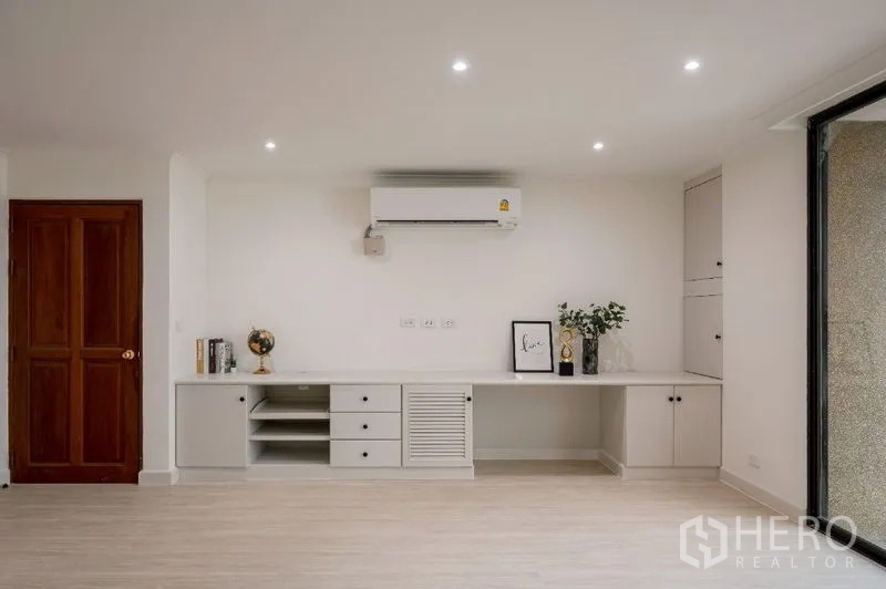 Condominium for sale - Minimalist wall-length desk with shelving and air conditioner.