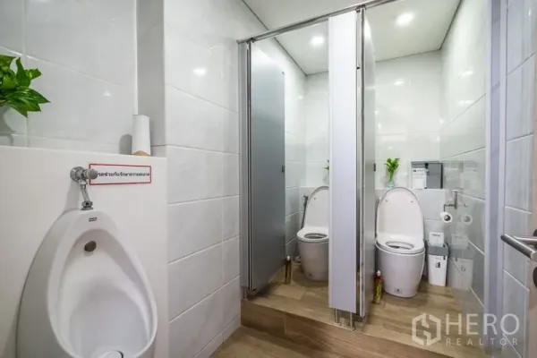 สำนักงาน ให้เช่า - ห้องน้ำปูกระเบื้องสว่างพร้อมห้องสุขาแยกสองห้องและโถปัสสาวะ