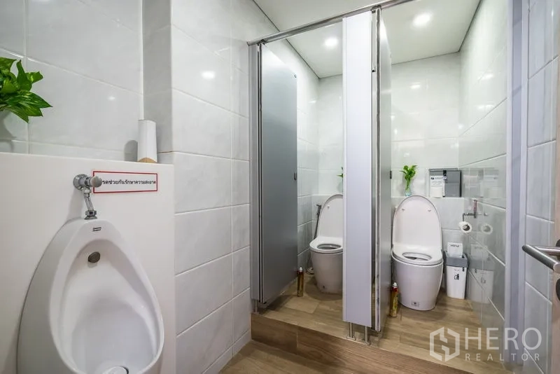 สำนักงาน ให้เช่า - ห้องน้ำปูกระเบื้องสว่างพร้อมห้องสุขาแยกสองห้องและโถปัสสาวะ