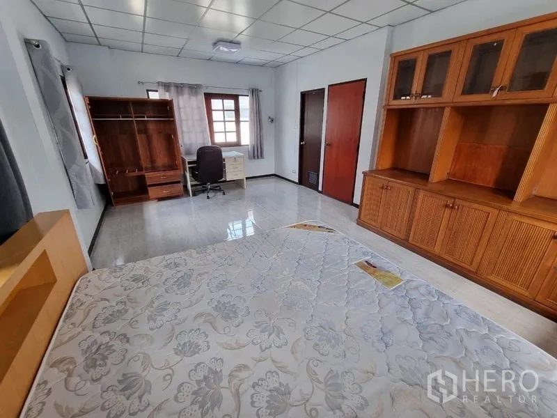 独立式住宅 出租在Nonthaburi - 主卧配内置衣柜、书桌与双门通道。